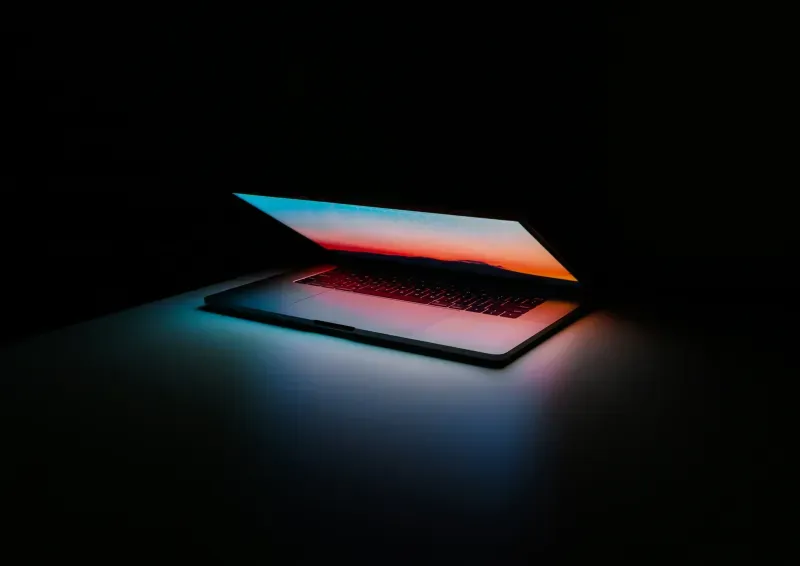 A notebook is shown on a table semi-closed but showing the light